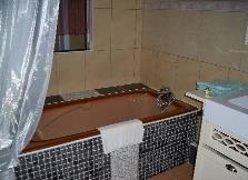 Suite avec lit double, WC, lavabo, baignoire et douche de la chambre d’hôte Wellington, en location au Château Borie Neuve dans l'Aude